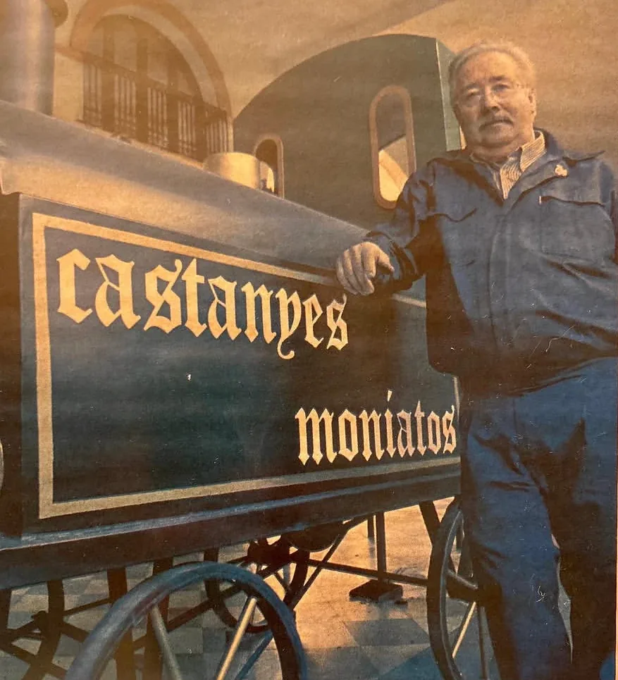 En Paco recolzat a la locomotora de castanyes i moniatos, sota les voltes